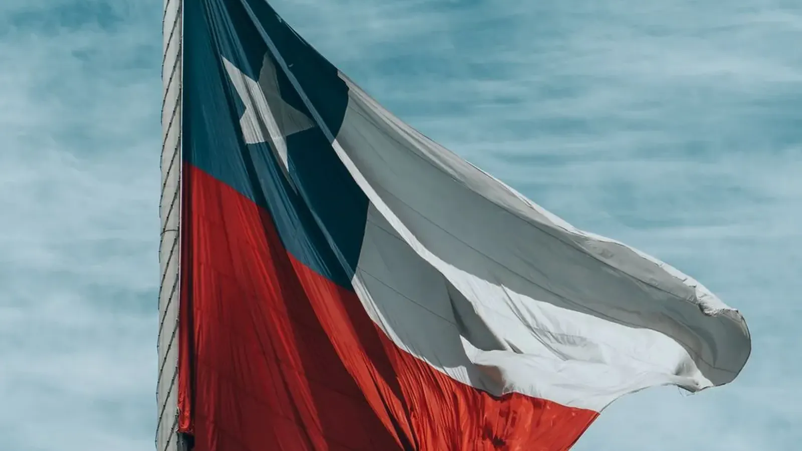 Bandera de Chile ondeando contra un cielo despejado en Fiestas Patrias