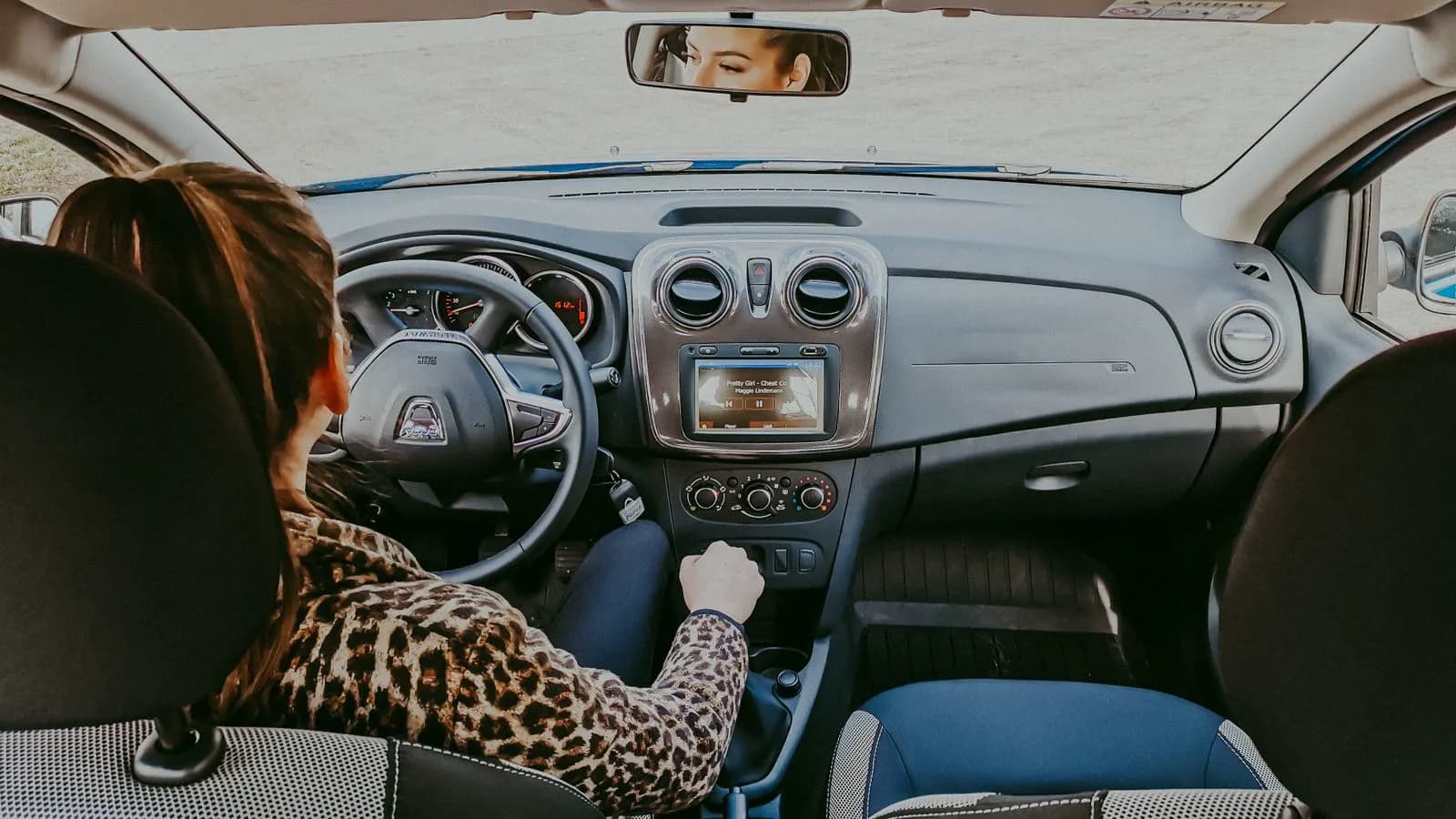 Mujer conduciendo sola de día, atenta al camino