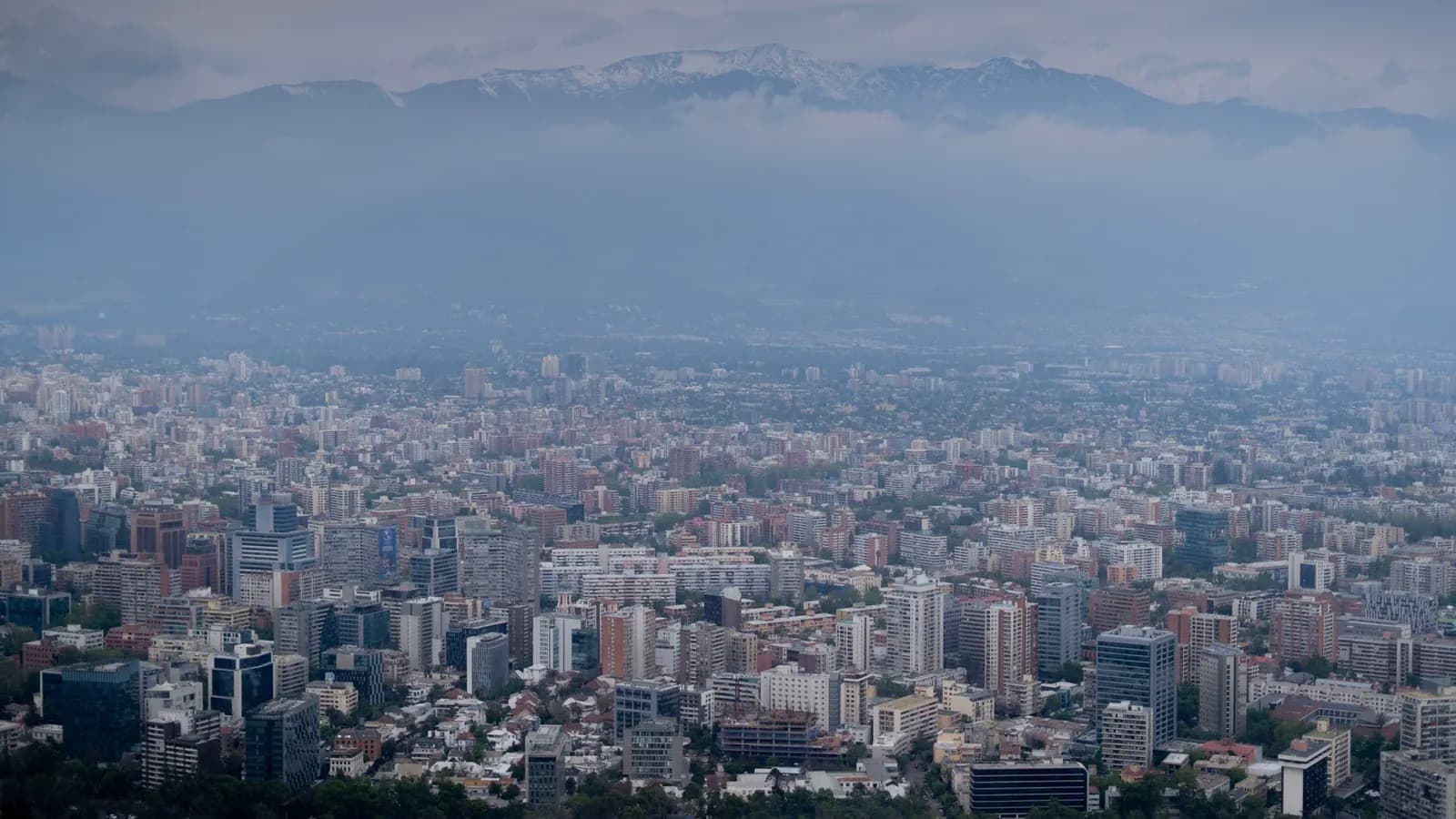 Vista aérea de Santiago con la cordillera de fondo, los barrios por donde las familias transitan camino al colegio
