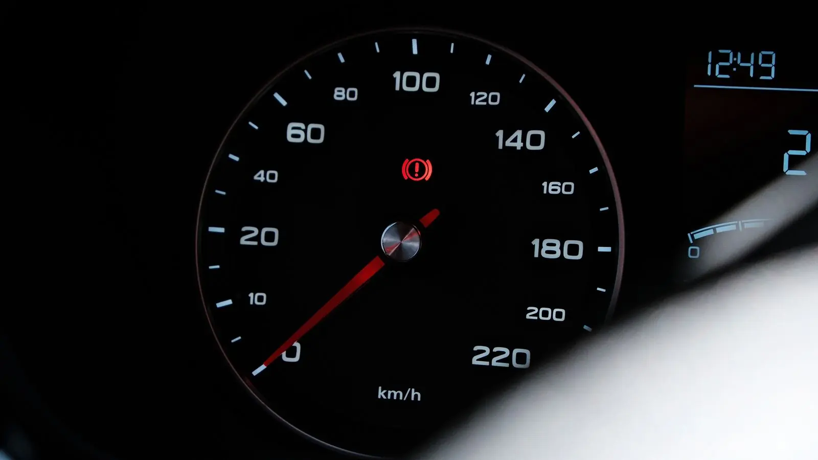 Velocímetro de un auto con el testigo rojo del sistema de frenos encendido
