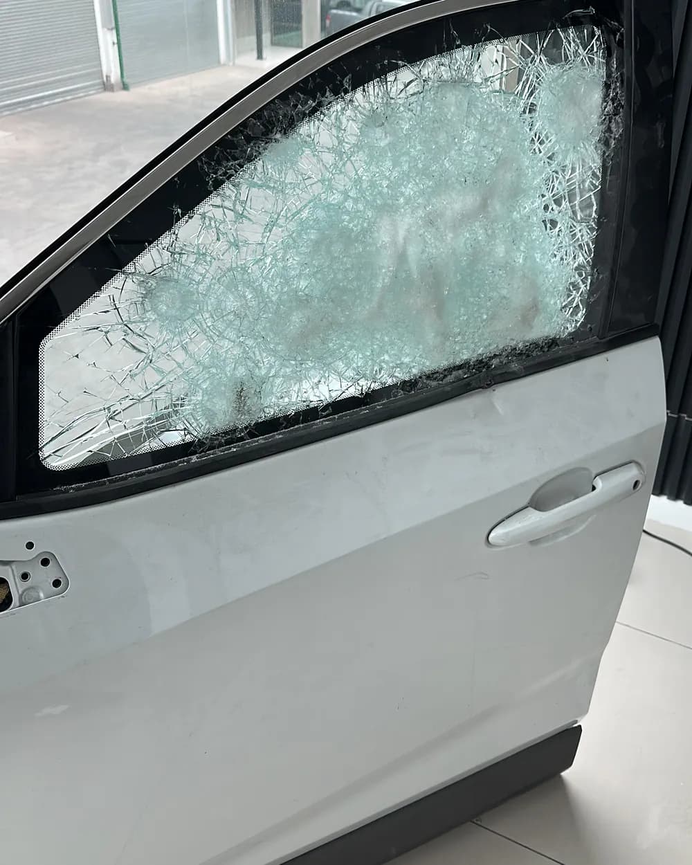 Vidrio blindado de una puerta estrellado tras varios impactos, pero sin ceder